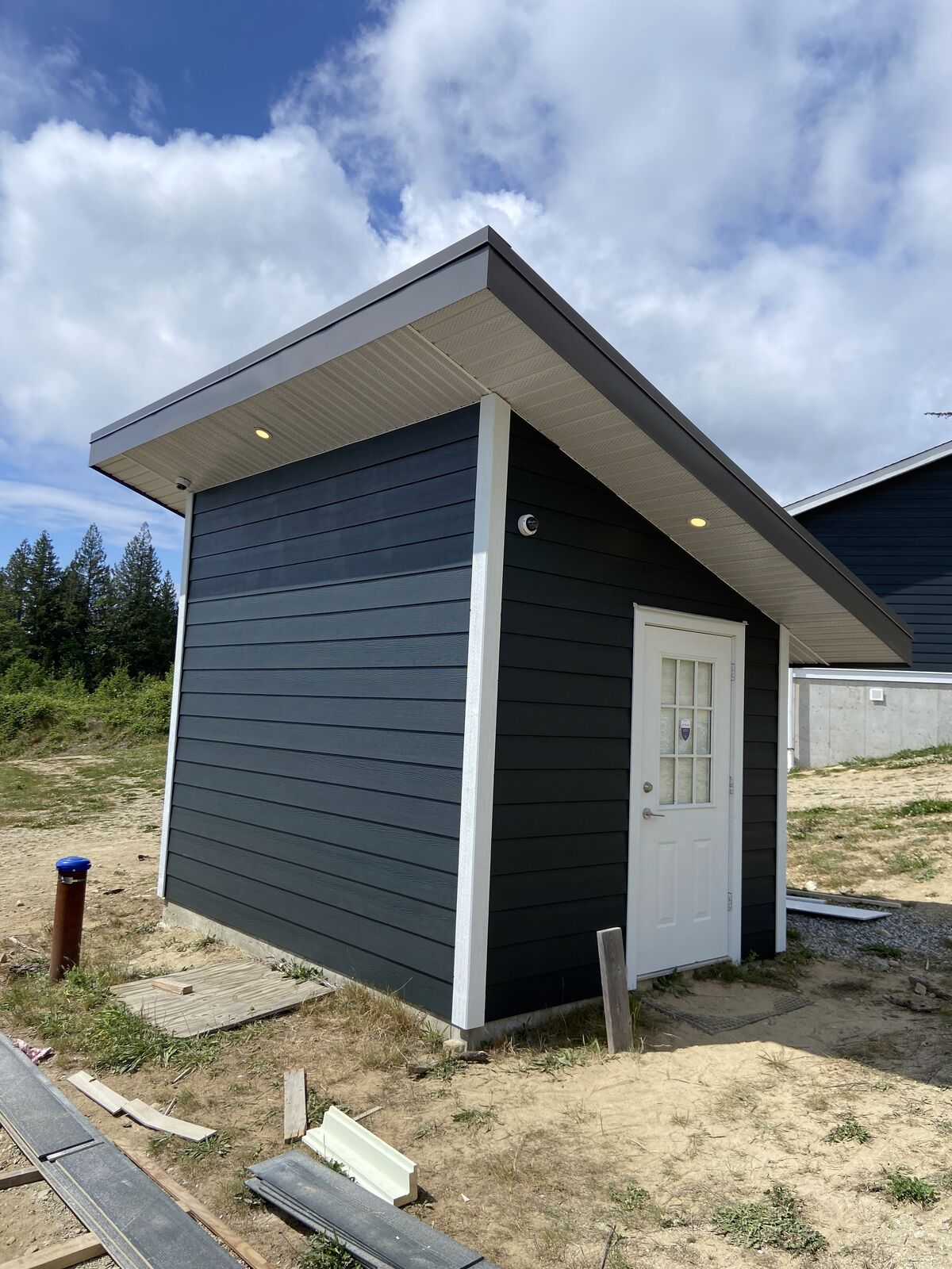 Finished bunkie with dark siding and white door